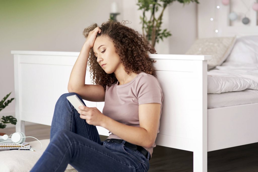 Worried Teenage Girl Using Mobile Phone